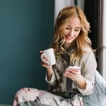 pretty blonde girl sitting window sill with cup - Thợ Kỹ Thuật