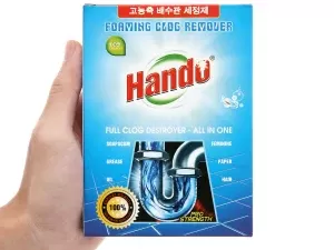 Một tay cầm hộp chất tẩy tắc cống dạng bọt thương hiệu Handu.