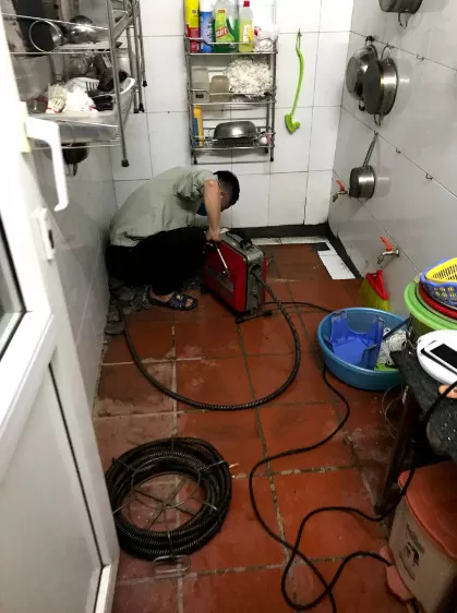 Hình ảnh minh họa nhân viên Thợ Miền Nam đang thông cống nghẹt bằng máy móc hiện đại tại Quận Bình Thạnh