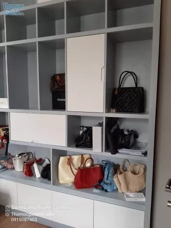 Hình ảnh thợ mộc Thợ Miền Nam đang sửa chữa tủ gỗ tại nhà khách hàng, thể hiện sự chuyên nghiệp và tận tâm