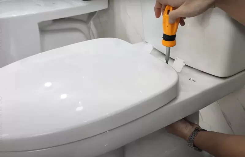 Nắp bồn cầu cũ bị ố vàng và hư hỏng cần được thay thế để đảm bảo vệ sinh và thẩm mỹ cho nhà tắm.